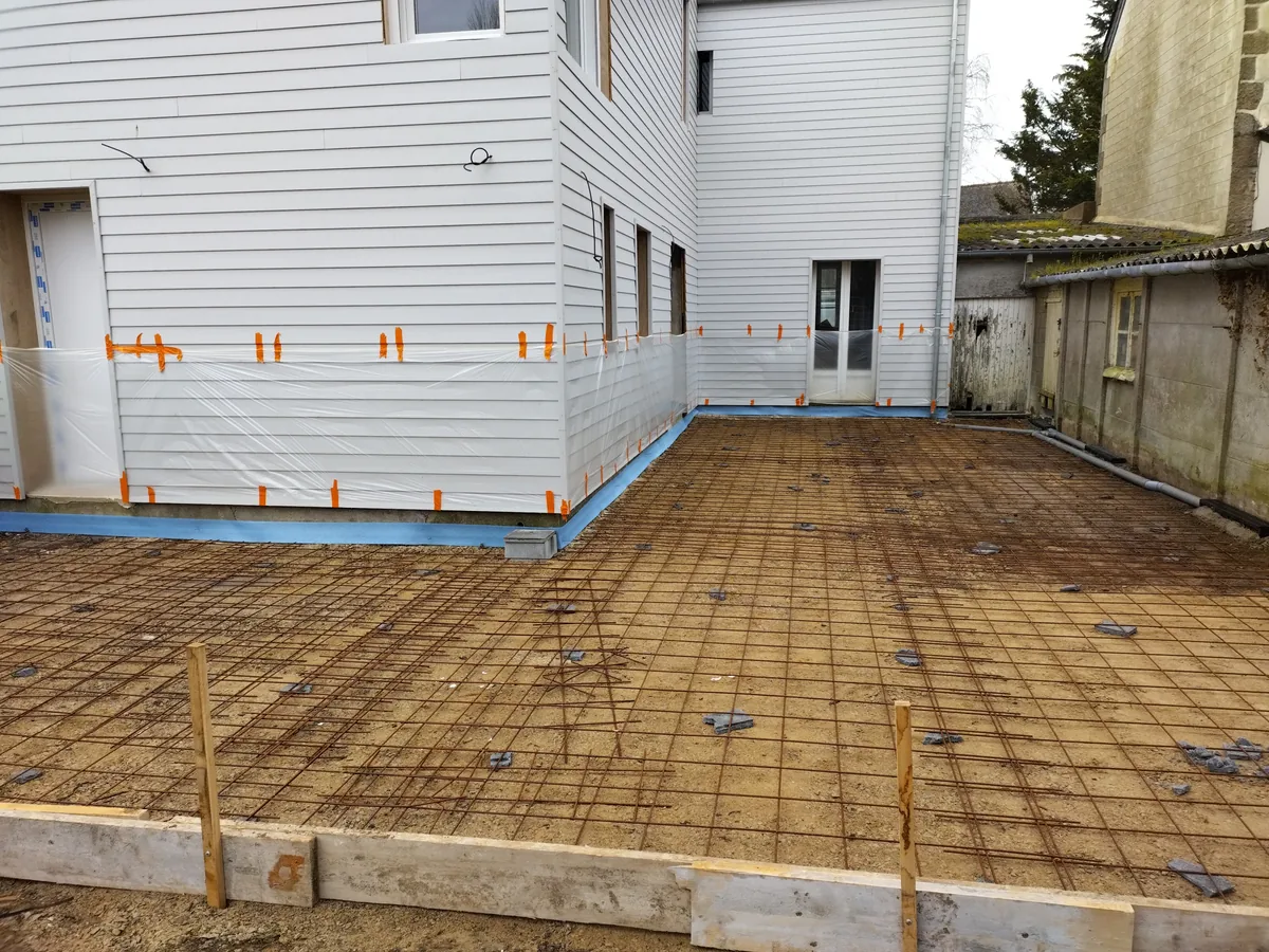 Treillis soudé posé sur cales sur un hérisson compacté, coffrage bois et bâche de protection avant coulage de la dalle