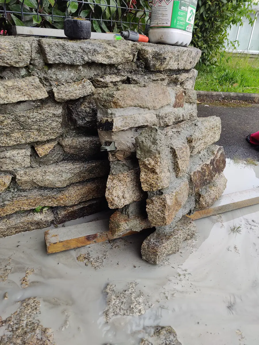 Coupe nette pratiquée dans un mur en pierre sèche, tranche de granit sciée visible