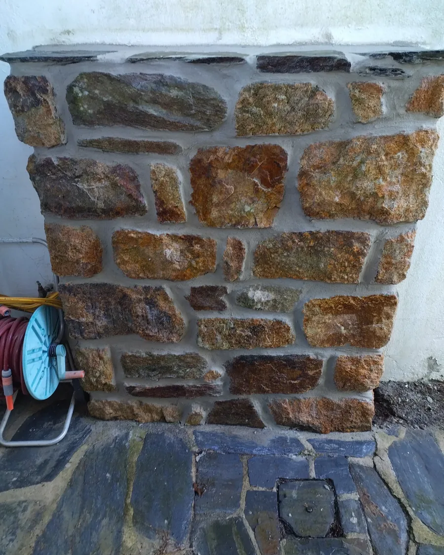 Mur en pierre du pays monté et jointoyé, dalles de schiste au pied