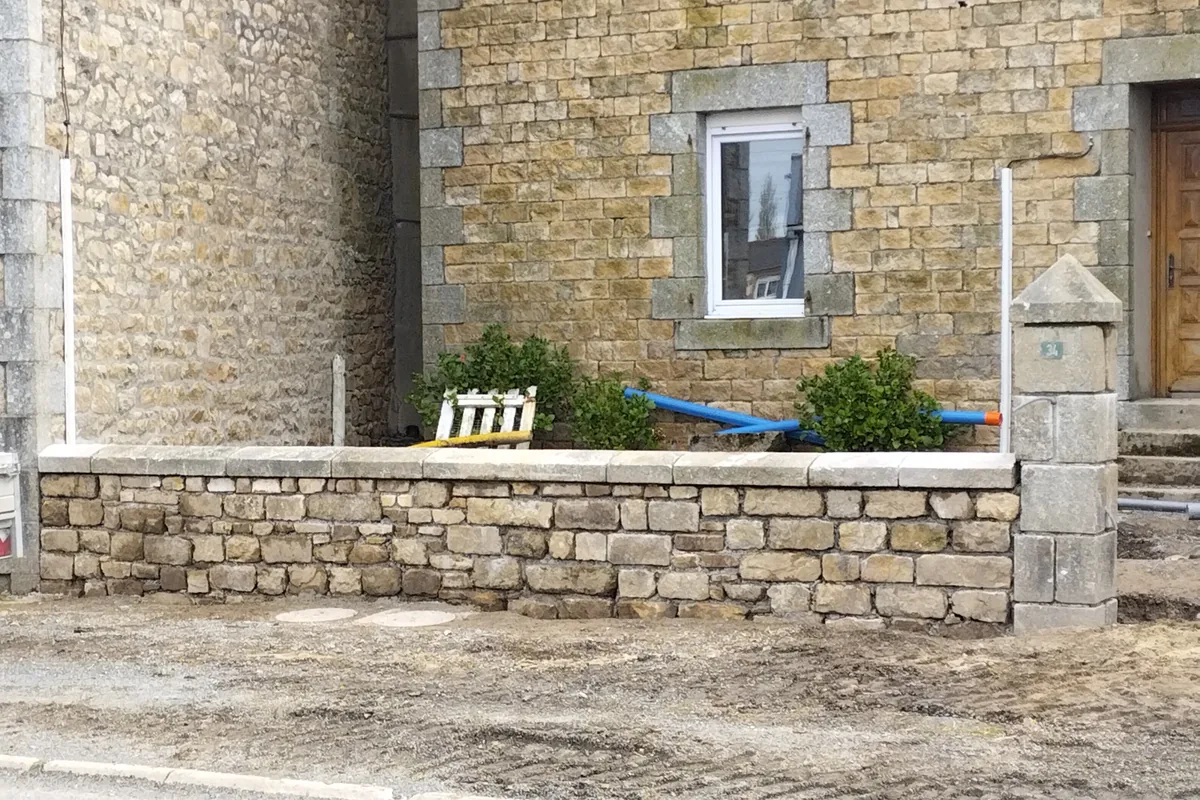 Muret de façade en pierre neuf, couronnement plat et pilier de portail en granit