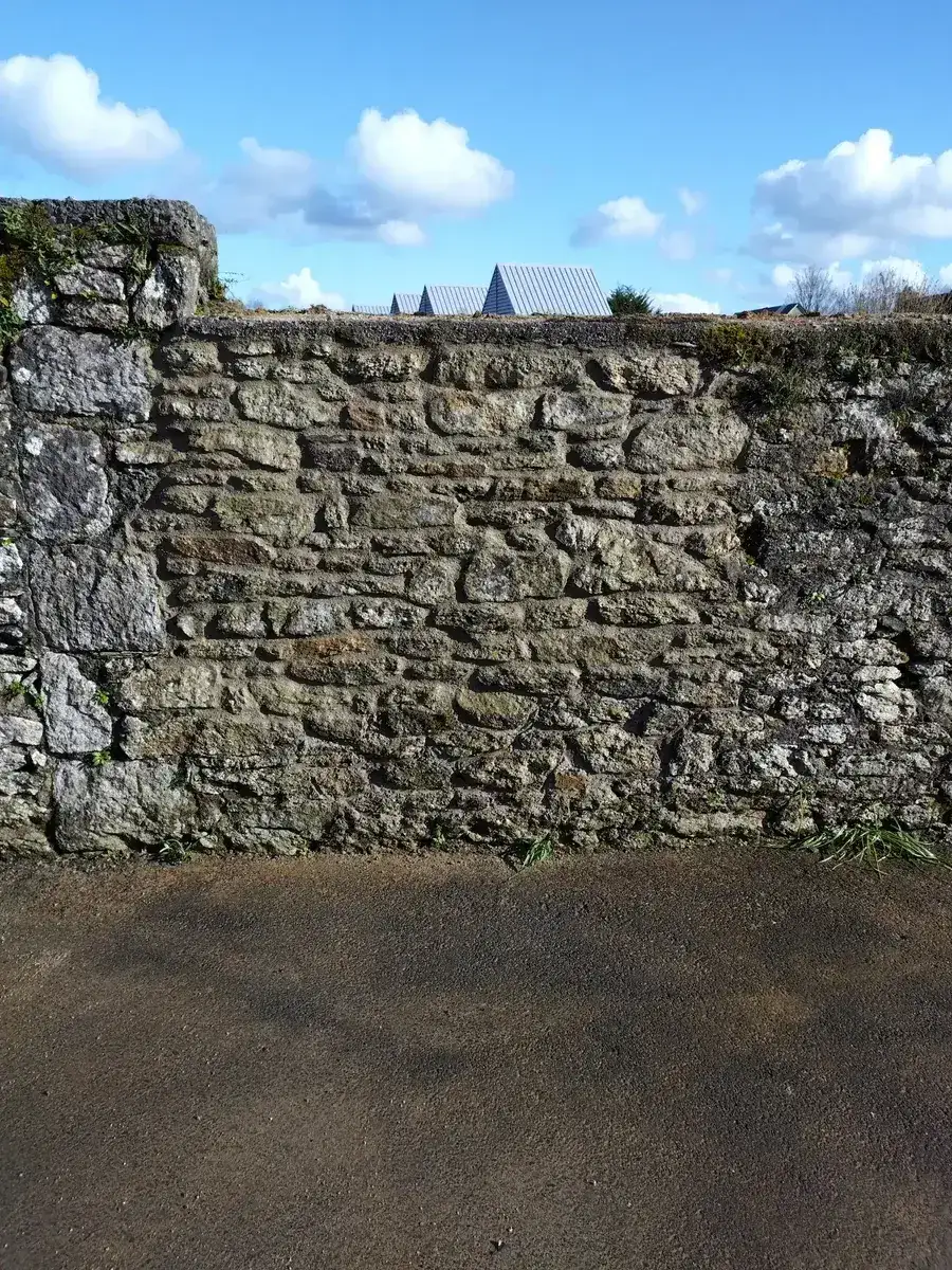 Mur de clôture en pierre remonté, parement refermé et lits réguliers